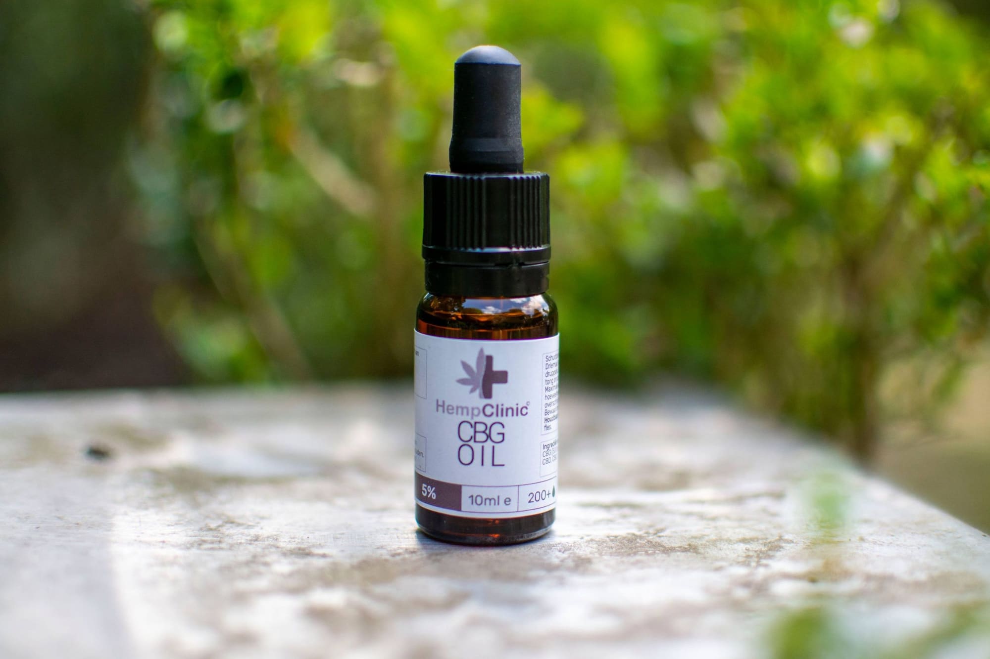 Flesje CBG-olie van Hemp Clinic op steen